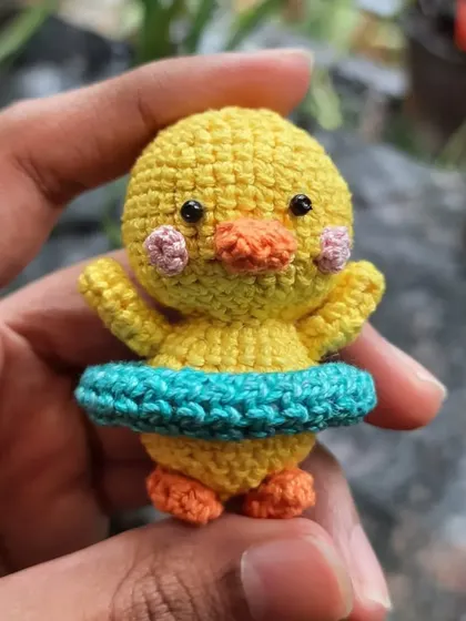 A close-up of the swimming duckling amigurumi. The tiny blush marks are hand-embroidered to give it an extra sweet look.