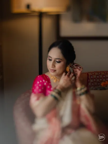 A soft-focus shot of the bride getting ready, capturing a quiet, behind-the-scenes moment.