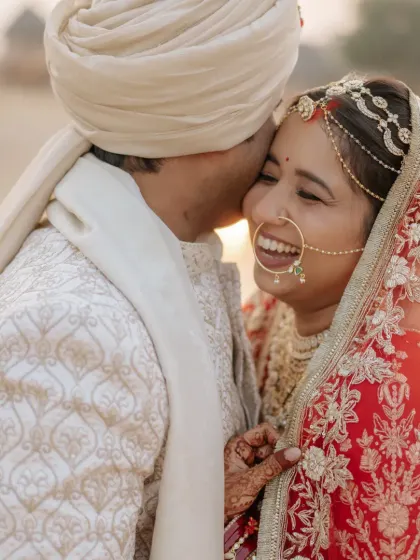A close-up of the couple sharing a happy, loving glance, with the bride's beautiful smile lighting up the frame.