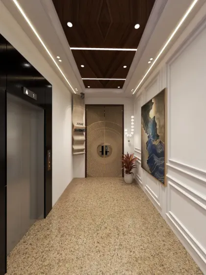 The entryway features a polished veneer ceiling with cove lighting, elegant wall moldings, and timeless terrazzo flooring for a grand first impression.
