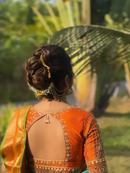 The side view of this traditional bun shows how it elegantly holds the hair away from the face, highlighting the bride's features and beautiful jewellery.