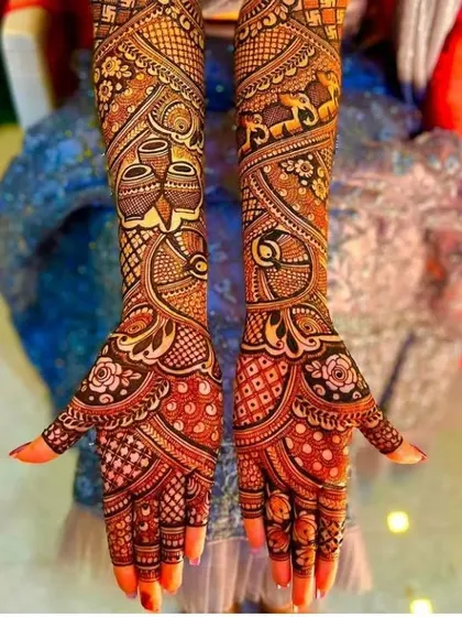A very rich and detailed design with kalash motifs, peacocks, and roses, covering the hands and arms completely.