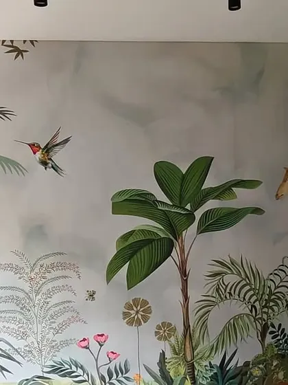 The completed jungle mural, featuring giraffes and hummingbirds. The final result is a vibrant and lively wall that transforms the entire room.
