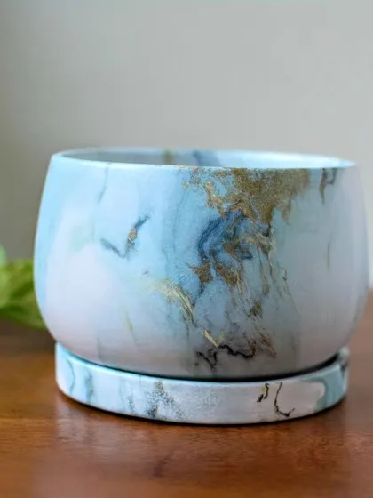 This is my Agate ceramic planter, which features a luxurious marble finish with swirls of blue and gold. It comes with a matching base plate to protect your furniture.