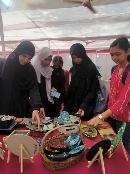 A group of young women curiously exploring the art and crafts at my stall. Events like these are a great way to inspire the next generation of artists and makers.