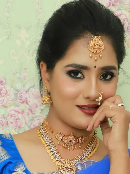 A close-up portrait showcasing the traditional jewelry that can be paired with this blue and aqua half saree.
