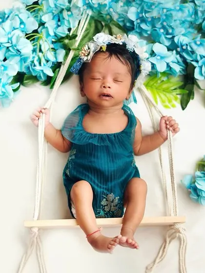 A tiny swing surrounded by flowers creates such a whimsical scene. I ensure all props, like this swing, are completely safe and secure for your precious little one.
