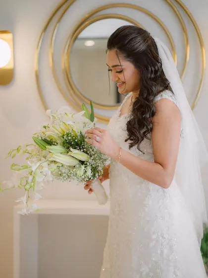 A quiet moment of reflection before the ceremony. Her half-up, half-down hairstyle with soft waves and natural makeup created a look of pure elegance.