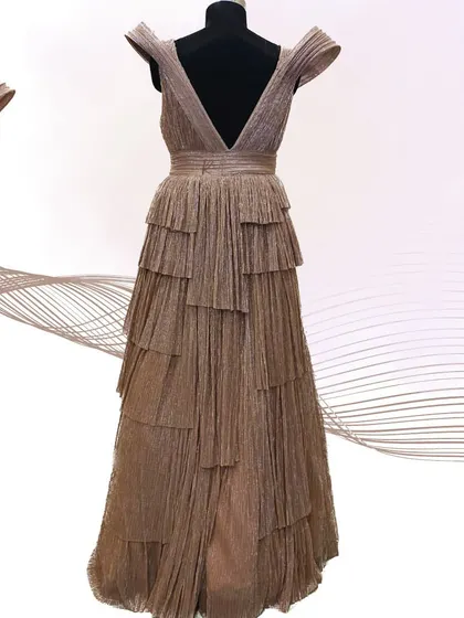 The full view of the rose gold gown on a mannequin, emphasizing its dramatic silhouette.