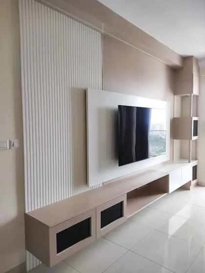 The combination of smooth surfaces and textured fluted panels on the TV wall adds depth and visual interest to the living room.