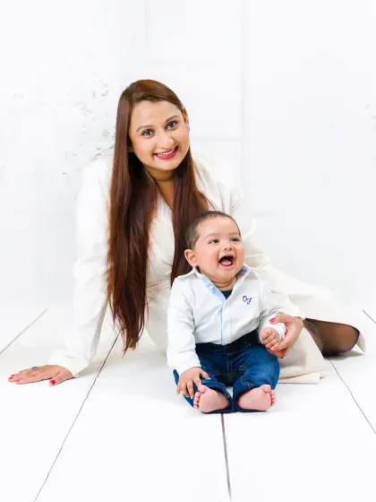 A mother and her baby share a laugh in this bright and happy portrait. The baby's joyful expression is a precious memory captured forever.