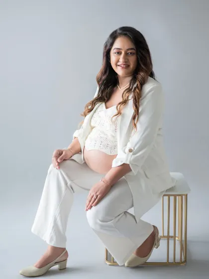 A powerful portrait for the modern mom-to-be. Dressed in a stylish white pantsuit, she exudes confidence and grace. This is what I call 'boss mom' energy.