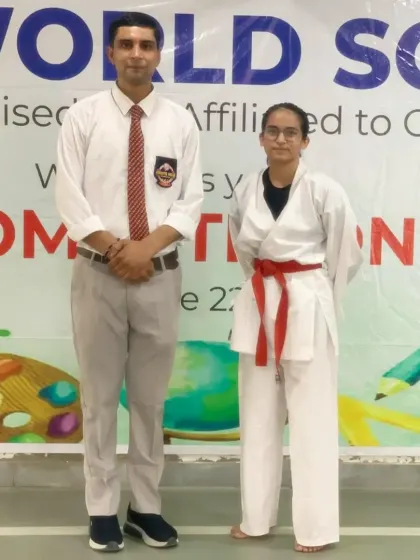 With a red-belt female student at a school competition. I coach my students personally at every event.