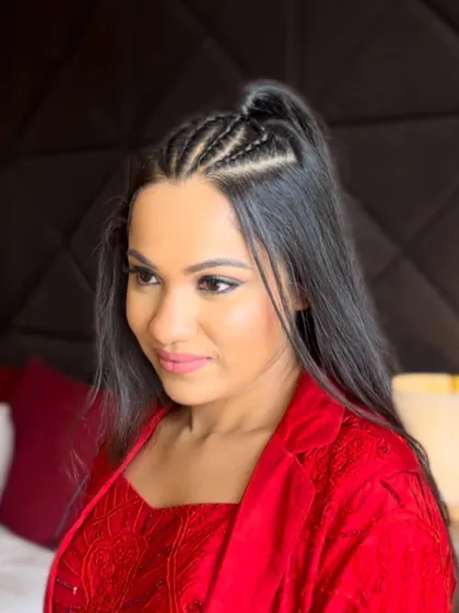 A clear shot of the finished half up hairstyle with the neat braids. This style keeps the hair away from the face while still showing off its length and texture.