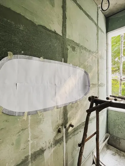 The first step in creating a custom mirror is an on-site mockup. We use a full-scale paper template to test the shape and placement, ensuring it perfectly fits the space and composition.