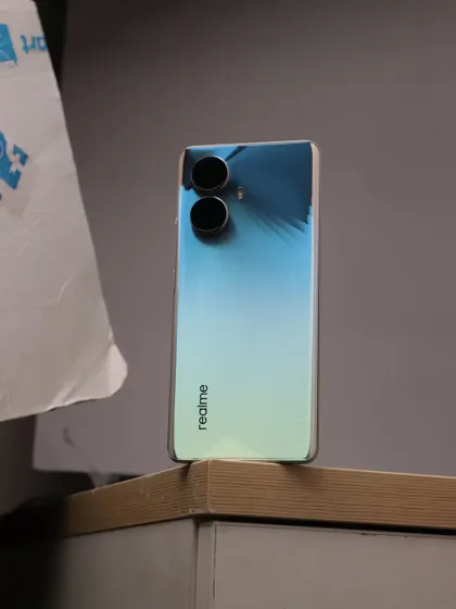 The unedited shot of the realme 10 Pro+ 5G on a desk, showing the simple setup before the background and lighting were refined in post production.