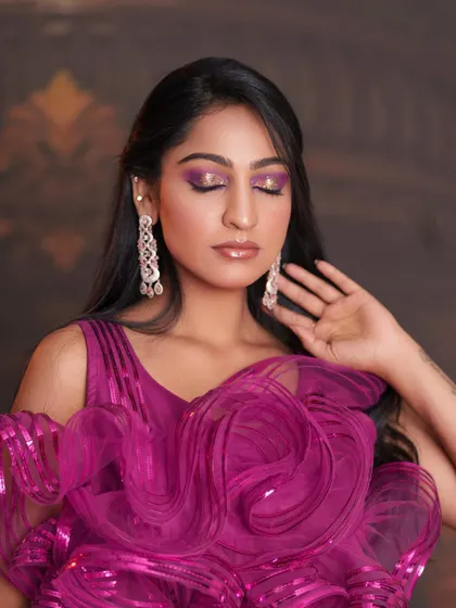 Eyes closed to showcase the glittery, blended purple and gold eyeshadow.