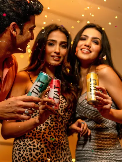 A vibrant and energetic party shot for Tilt Wine. The falling confetti and happy expressions of the models create a celebratory mood, positioning the canned wine as the perfect drink for a fun night out.