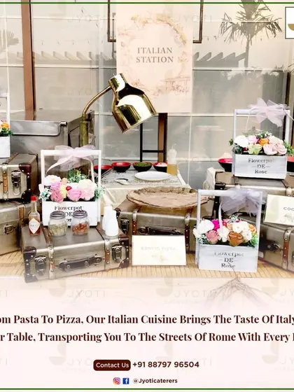 A charming Italian station setup with vintage suitcases and floral baskets. This station brings the taste of Italy to your event, from fresh pasta to gourmet pizzas.