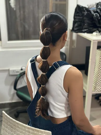 A playful and unique bubble ponytail, created with evenly spaced sections for a fun, geometric look.