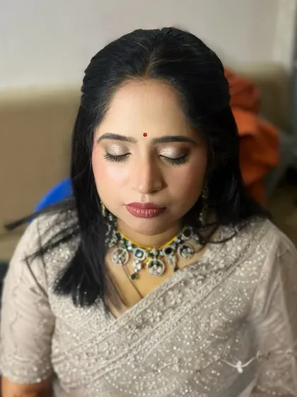 A very subtle and minimalistic look for a guest. The makeup is designed to enhance her natural beauty, with a soft shimmer on the eyes and a muted lip.
