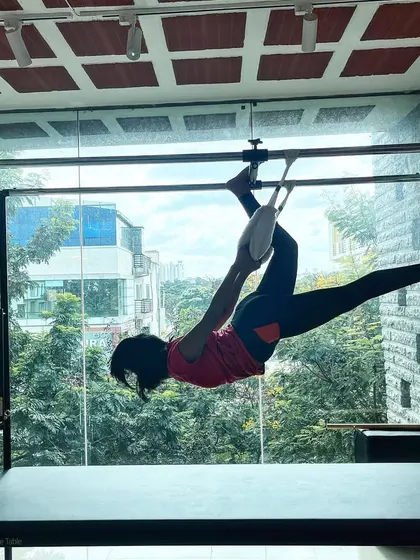 Embrace the challenge. This client works on her flexibility and strength with this hanging pose on the Cadillac.