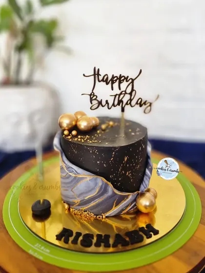 I love the effect of fondant marbling. This black and grey marbled cake with gold spheres and a "Happy Birthday" topper is a great example of a modern and masculine design.