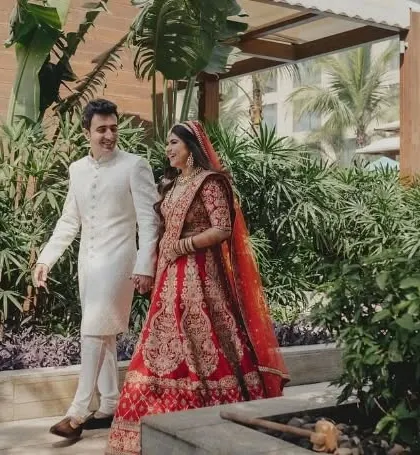 The couple taking a stroll through the lush green pathways of their wedding venue.