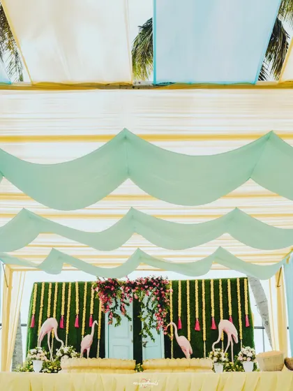 The draped ceiling of the Haldi tent, using waves of light blue and yellow fabric to create a beachy feel.