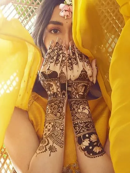 A beautiful shot of a bride with her mehandi, which features palace architecture on the back of her hands, giving a royal feel.