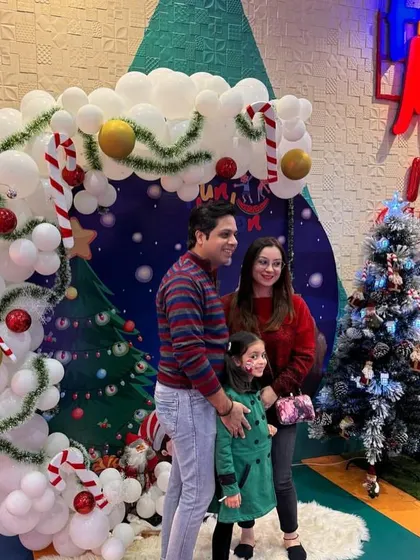 A family captures a beautiful moment during our Christmas celebration, posing in front of the festive decor.