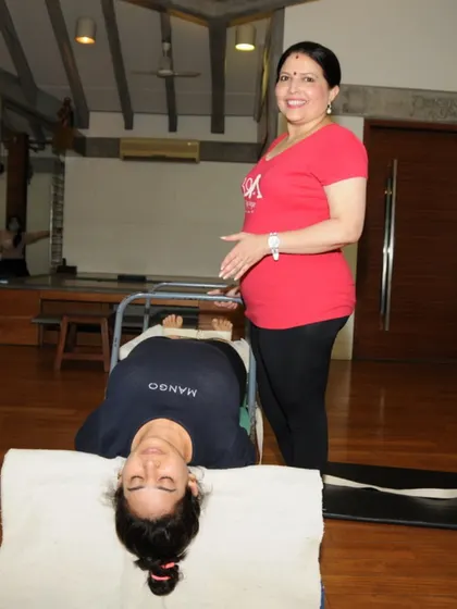 "Move with intention, breathe with purpose, and find stillness within." This student, in a supported restorative pose, is embodying this principle.