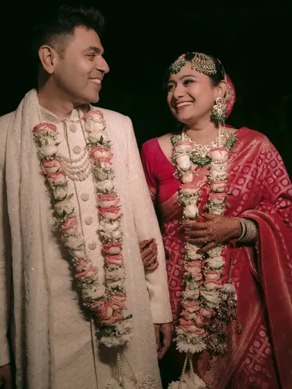 A happy, candid moment between the couple right after the wedding ceremony, surrounded by warm lights.