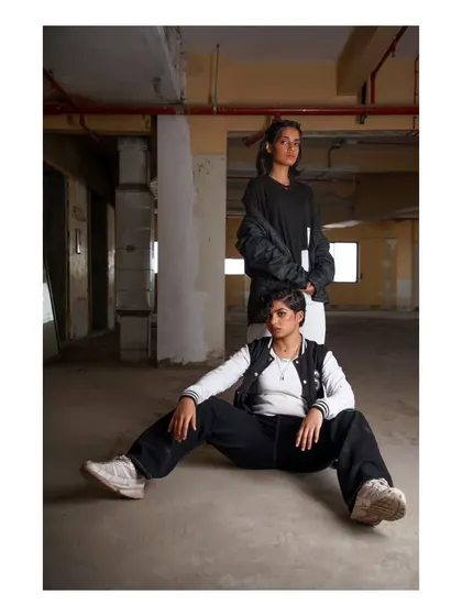 A group shot from the "No Label" campaign, showing two models with different styles coexisting in the same raw, industrial space.