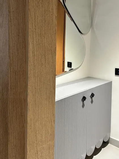 A detail of a custom-built storage cabinet. This piece features a unique scalloped base and fluted door fronts, showcasing our attention to creative design details.
