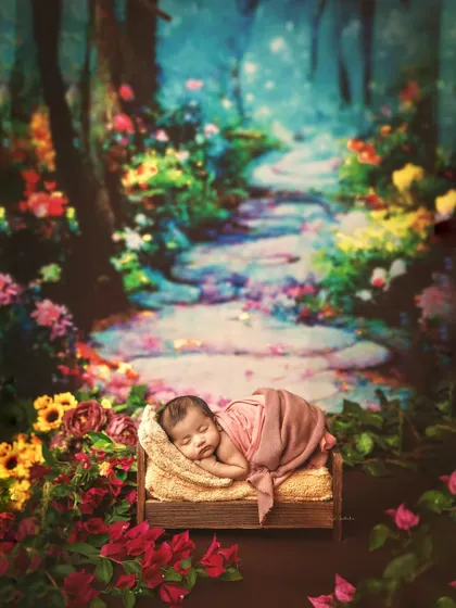 A newborn sleeps peacefully on a tiny bed, set against a painterly backdrop of an enchanted forest path. This is a fine art portrait designed to look like a dream.