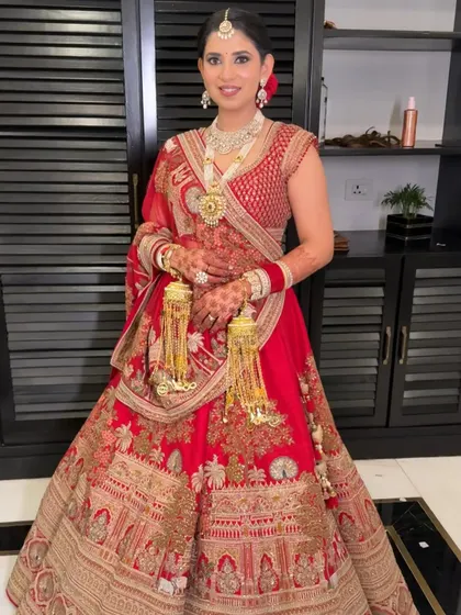 A full-length view of Manika's classic red bridal look. The makeup was designed to be just as impactful from a distance, ensuring she looked breathtaking from every angle.