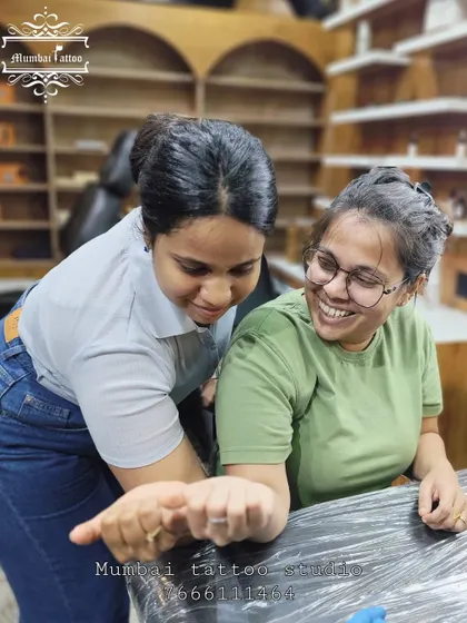 A friend admiring her bestie's new tattoo. The joy and excitement in these moments are what make our job so rewarding.