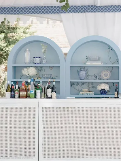 A closer look at the bespoke bar we designed for this baby welcome. The arched shelving features chinoiserie-style wallpaper and delicate porcelain, adding a layer of sophisticated, personalized detail to the event.