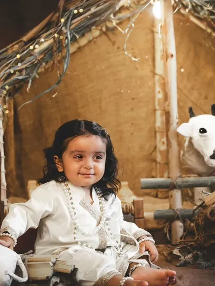 A sweet portrait of a little boy in our Janmashtami village set, surrounded by his little toy animal friends.