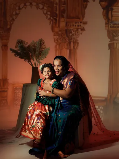 A heartwarming mother-daughter photoshoot, celebrating the bond of family. The makeup is soft and timeless, inspired by classic paintings.