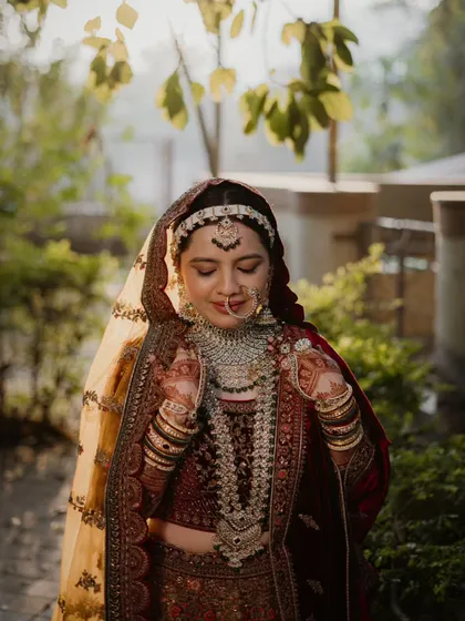 A beautiful, soft-lit portrait of the bride with her eyes closed, as if making a wish or cherishing a quiet moment on her big day.