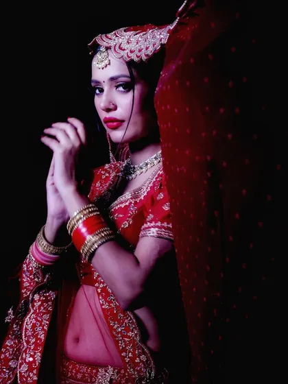 This portrait focuses on the bride's pose and the flow of her traditional attire. It's a great example of a creative studio shoot, playing with shadows and form to create a striking image.