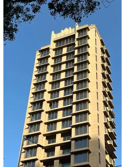 The strong, clean lines of this residential tower against a clear blue sky. The facade's rhythmic pattern of windows and balconies creates a sense of order and modern elegance.