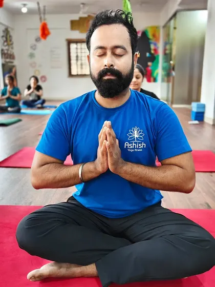 A student with a beard sits in deep meditation, embodying the calm and focus we cultivate.