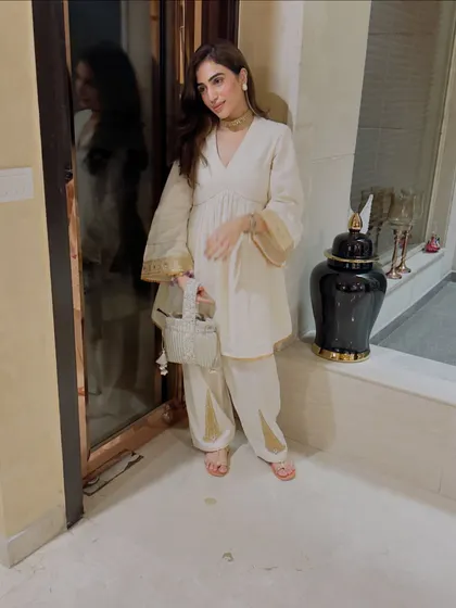 A full-length view of the off-white suit, highlighting the flared sleeves and relaxed silhouette.