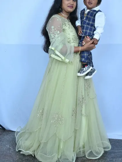 A happy mother and child moment, with the mother wearing a lovely light green embroidered gown.