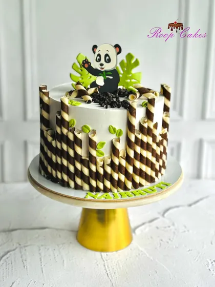 A cute little panda theme cake, with chocolate-striped wafer rolls creating a bamboo-like effect.