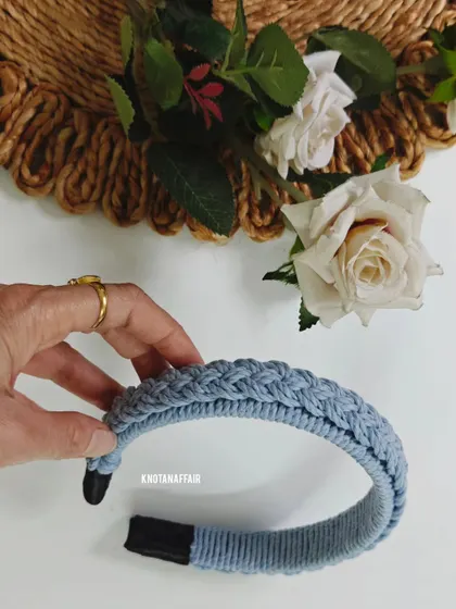A closer look at the denim blue braided macrame hairband. The intricate knotting creates a stylish and unique accessory.