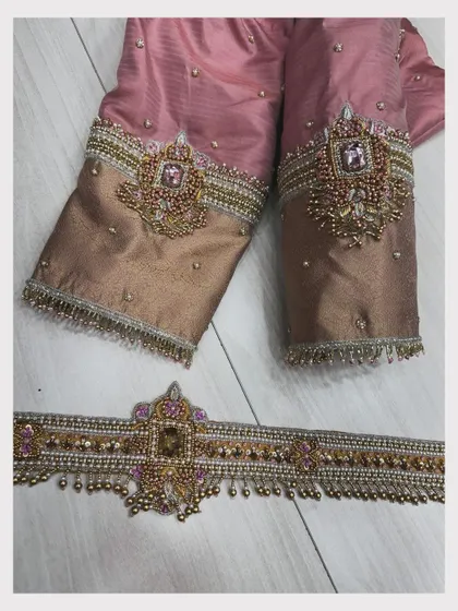 The blouse sleeves paired with a matching embroidered hip belt (vaddanam).